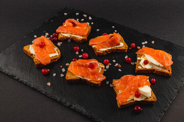 Salmon pieces on fresh toast spread with butter and a slice of mozzarella