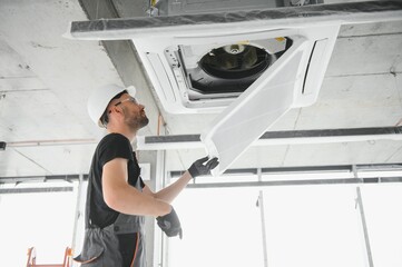 technician cleans air conditioner system in a modern apartment