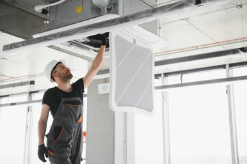 technician cleans air conditioner system in a modern apartment