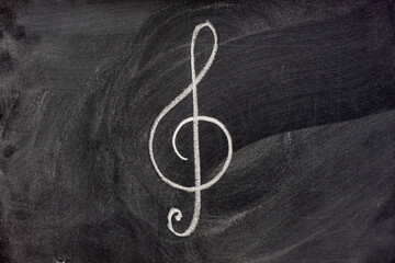 common musical notation sign, treble clef or music symbol in general, sketched with white chalk on...
