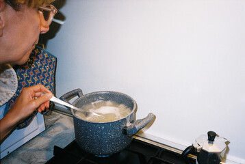 woman cooking homemade pasta in traditional italian kitchen, film photography