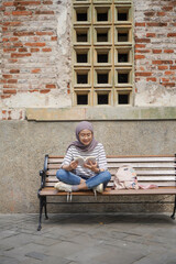 Fototapeta premium asian muslim woman reading on the bench