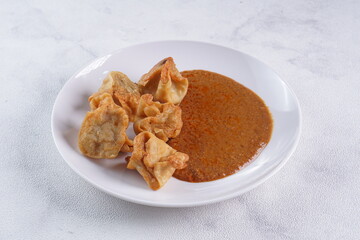 batagor,is a street food that is very popular in Indonesia.made from fish, tapioca and seasoning wrapped in dumplings then fried. Served with spicy peanut sauce. photographed with studio light