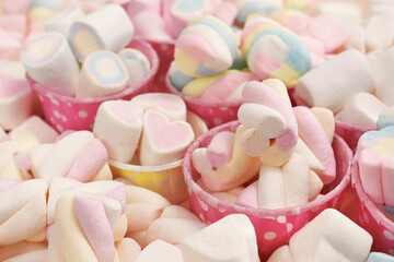 Confectionery and sweeties varieties background: light pink and white marshmallows, sugar confetti,...