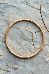 A gold bracelet is sitting on a rock