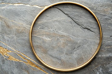 A gold colored ring is sitting on a gray stone