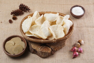 Traditional Indonesian kerupuk snacks, made from catfish, served in a wooden place on a white table with a studio lighting