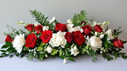Elegant red and white rose centerpiece with peonies and greenery.