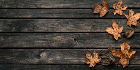 Fototapeta premium Dried autumn leaves on dark wooden background.