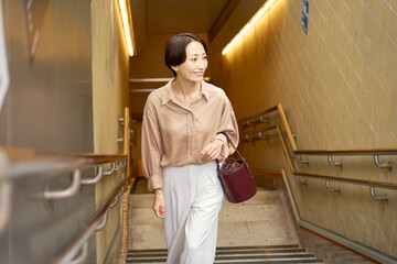 地下鉄の階段を上る女性