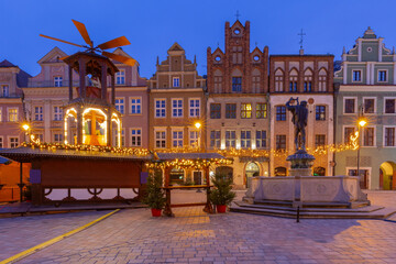 Festive market stalls, Christmas carousel and historic house facades, Poznan, Poland