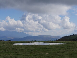 山々が広がる草原の小さな湖