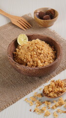 "Abon Ikan" is a typical food from Indonesia. namely a type of floss made from catfish meat, in a wooden bowl photographed in the studio with a wooden theme prop