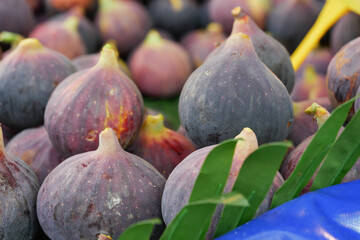 Fresh, succulent figs beautifully displayed alongside vibrant green leaves for decoration