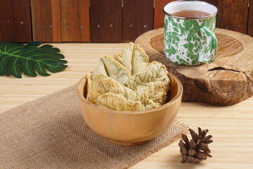 Crispy and savory spinach chips. Made from spinach leaves and rice flour, in a wooden bowl, with...