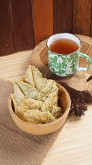 Crispy and savory spinach chips. Made from spinach leaves and rice flour, in a wooden bowl, with wood properties, and studio lighting