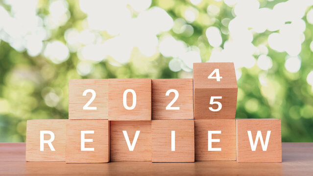 Review 2025. Flips wooden cube and changes words Review 2024 to Review 2025. Business growth, goals, planning. Business Review 2025 New Year concept