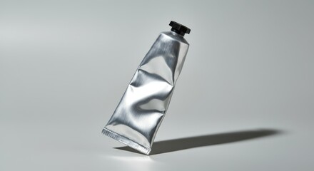 Silver metal tube with black cap, casting shadow