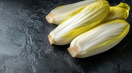 Close up of fresh raw Belgian Endives (chicory) on a black table. Ai generated image