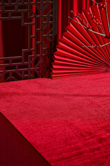 High angle shot at red covered table, which decorated by chinese style with paper fan, wooden...