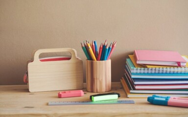 Fototapeta premium A warm cosy work corner, books and notebooks, coloured pencils in a pencil case on the desk