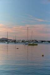 Stunning sunset over a European seaside town harbor with calm waters and moored boats