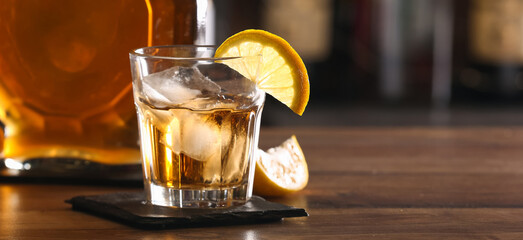 Glass of cold rum on table in bar