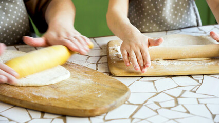 Mother and child rolling dough together