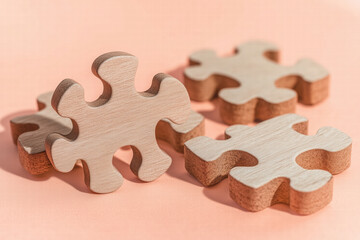 Wooden puzzle pieces on soft peach background, symbolizing creativity Generative Ai