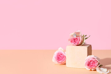 Decorative podium with stylish ring and beautiful roses on colorful background