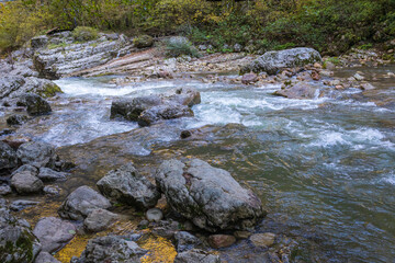 a stream of water in a stone riverbed, spewing noise and rumbling, making its way to free water