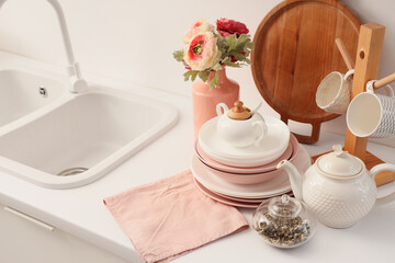 Teapot and dinnerware on counter in kitchen. Closeup