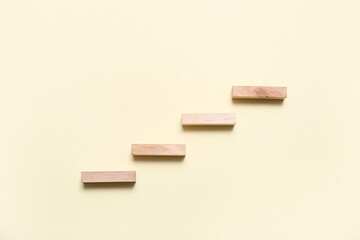 Ladder made of wooden blocks on beige background