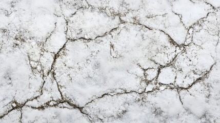 Fototapeta premium Snowy ground texture with intricate cracks highlighting natural patterns in a winter landscape closeup top view of snow crust.