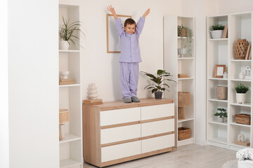 Cute little boy on high commode at home. Child in danger