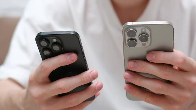 A person is comparing two different smartphones, showcasing technology trends and various user preferences