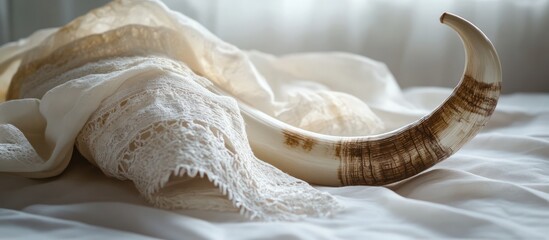 Shofar horn placed on a white prayer talit symbolizing spiritual significance and religious traditions in Judaism
