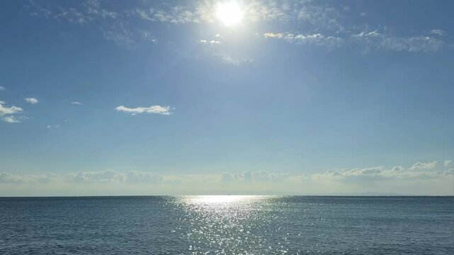 青い空に輝く太陽の光をうけてキラキラと輝く美しい海の波景色