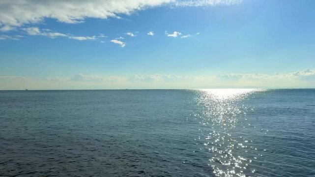 青い空に輝く太陽の光をうけてキラキラと輝く美しい海の波景色