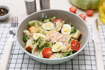 Bowl with tasty chicken Caesar salad on white background, closeup