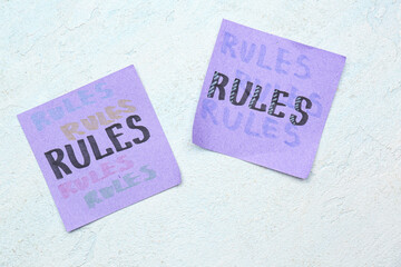 Sticky notes with word RULES on white grunge background