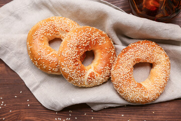 Tasty bagels with sesame seeds on wooden background