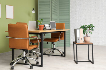 Interior of comfortable modern office with laptops prepared for meeting