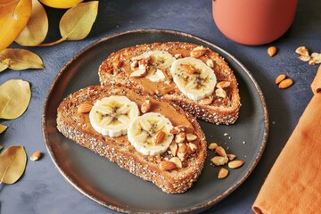 Delicious crunchy multigrain toast with almond butter and banana healthy breakfast recipe cozy kitchen close-up view