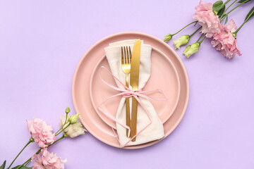 Stylish table setting with beautiful eustoma flowers on lilac background