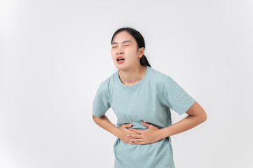 A sick, uncomfortable Asian woman touching her stomach, suffering from period cramps or stomachache.