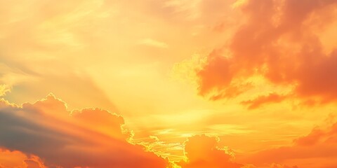 Obraz premium Vibrant orange and yellow hues fill the cloudy sky during sunrise and sunset, creating a stunning gradient. This beautiful twilight sky showcases a blend of hot and cool tones with sunbeams peeking