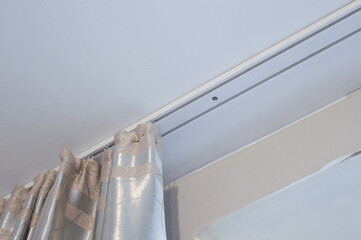 someone pulling back a set of silver-gray curtains with shiny pattern home interior design energy...