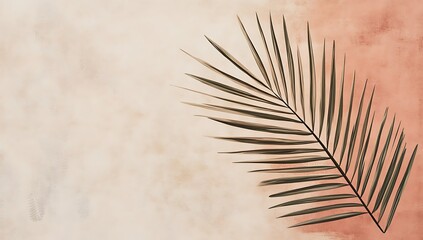 Obraz premium Single palm frond on a peach and beige watercolor background.