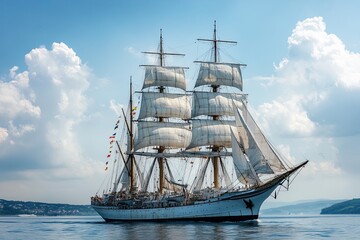 A majestic tall ship sailing on calm waters under clouds.